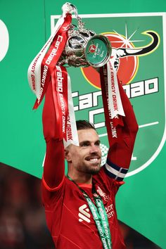 a man holding up a trophy in the air