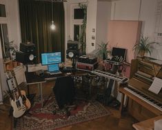 a living room filled with musical instruments and a laptop computer sitting on top of a rug