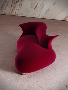 a red chair sitting on top of a floor next to a white marble countertop