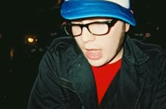 a young man wearing glasses and a hat making a surprised face with his mouth open