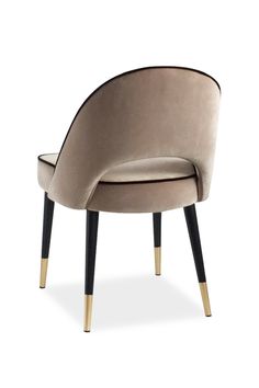 an upholstered chair with gold legs