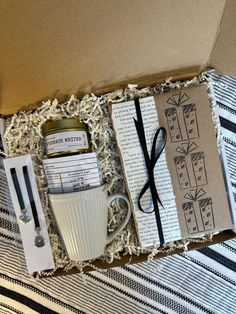 an open box with some items in it on top of a striped tablecloth and black and white stripes