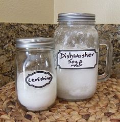 two mason jars filled with white sugar sitting on top of a table