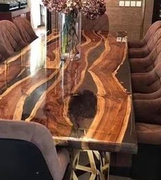 a dining room table with chairs and a vase filled with flowers on top of it