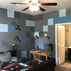 a bedroom decorated in shades of blue, grey and black with a desk and chair