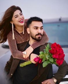 a man carrying a woman on his back while holding a bouquet of flowers in front of him