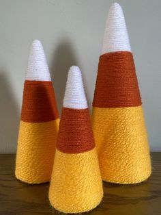 three knitted cones sitting on top of a wooden table