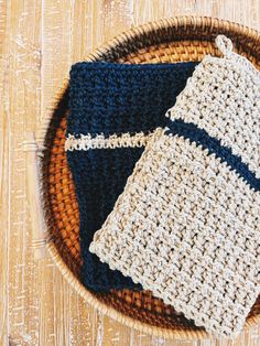 two crocheted dishcloths sitting on top of a woven basket next to each other