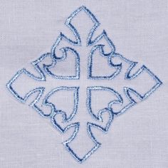 a cross with hearts on it is embroidered onto the side of a piece of cloth