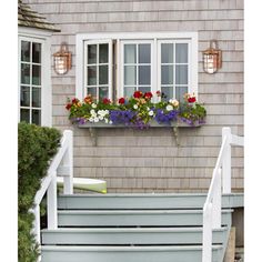 a house with flowers in the window boxes