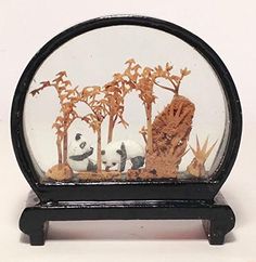 there is a small glass case with animals in it and trees inside the glass dome