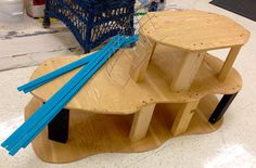 a wooden table with several pieces of wood on it and some blue sticks sticking out of the top