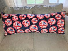 a couch with a pillow that has baseballs on it