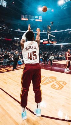 a basketball player dunking the ball into the air in front of an arena full of people