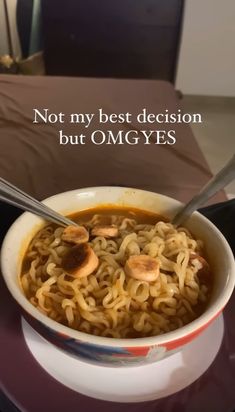 a bowl filled with noodles and mushrooms on top of a table