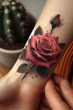 a woman's arm with a rose tattoo on it and a cactus in the background