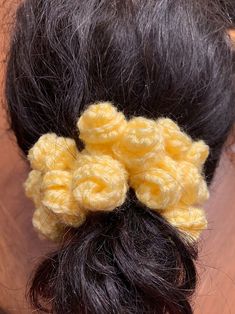 a close up of a person's hair with crochet flowers in it