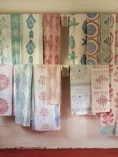 colorful towels hanging on a wall next to a towel rack