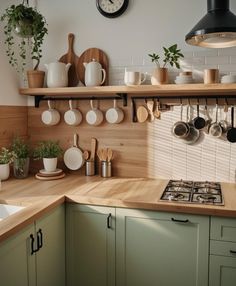 a kitchen counter with pots and pans hanging on the wall next to an oven