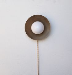 a white ball hanging from the side of a wall with a rope attached to it