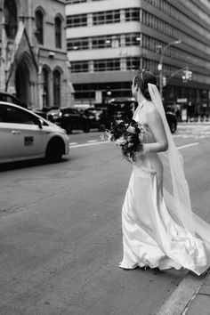 a woman in a wedding dress walking down the street