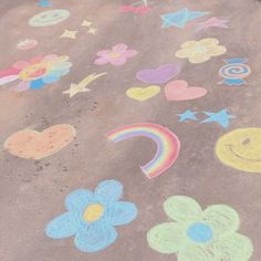 the sidewalk is covered in chalk and has flowers, hearts, stars, and rainbows drawn on it