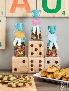 a table topped with lots of cookies and candies next to wooden blocks on top of each other