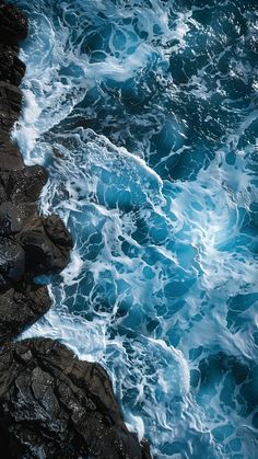 the water is blue and choppy with waves coming in from behind it, as seen from above