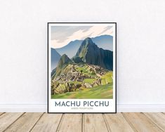 the machu picchu poster is hanging on a wall in front of a wooden floor