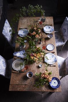 a table set for thanksgiving dinner with flowers and plates on it, in front of the words from our table to yours happy thanksgiving