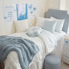 a bed with white sheets and blue pillows