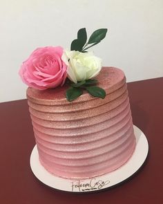 a pink and white cake with flowers on top