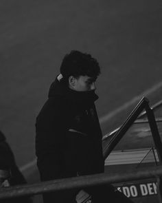 black and white photograph of a man walking down stairs with his hand on the railing