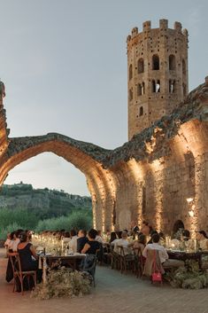 people sitting at tables in front of an archway