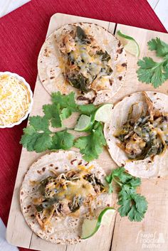 three tortillas on a cutting board with cilantro and cheese