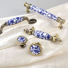 two blue and white porcelain handles with matching knobs on a white satin sheet,