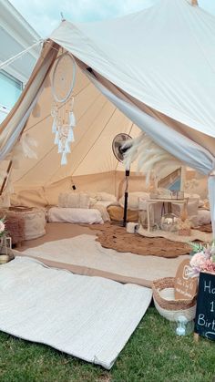 a birthday party tent set up in the grass with flowers and decorations on it's side