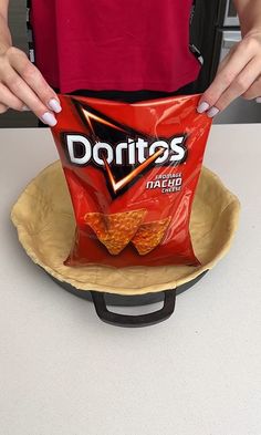 a person holding a bag of chips on top of a plate