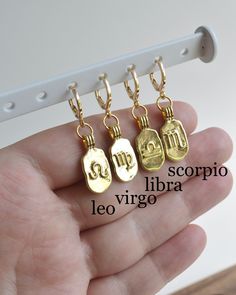 Single 18K gold plated huggie hoop earring featuring a gold filled embossed zodiac symbol charm. Sold as an individual earring or as a pair - purchasing a single earring means you can wear your sun/moon/rising signs, or your sign + the sign of a loved one. Perfect for second and third earring holes. Please select either Single Earring or Pair. Single Earring selections will be sent ONE earring only. Pair selections will be sent two identical earrings. To purchase multiple different Single Earrin Gold Celestial Huggie Earrings As Gift, Gold Celestial Huggie Earrings For Gift, Gold Zodiac Sign Earrings Gift, Rising Signs, Sun Moon Rising, Scorpio And Libra, Earring Hole, Huggie Earring, Moon Rising