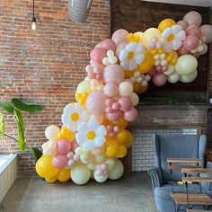 the balloon arch is decorated with pastel colors and white, yellow, pink, and grey balloons