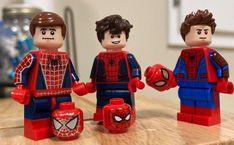 three lego spider - man figures on a table