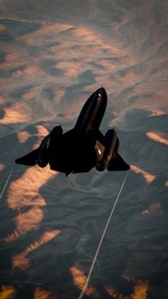 an airplane flying through the sky with clouds in the background