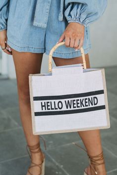 Elevate your weekend style with our Bamboo Hello Weekend Tote Bag. The beige square tote boasts a burlap-like fabric and brown trim, accented by bamboo straps. Featuring "Hello Weekend" on the front, this bag is perfect for a day out or a trip to the beach! Casual Rectangular Shoulder Bag For Weekend, Trendy Summer Canvas Bag For Weekend, Trendy Summer Weekend Canvas Bag, Canvas Bags For Spring Weekend, Trendy Natural Canvas Bag In Rectangular Shape, Canvas Bag For Weekend In Spring, Canvas Bag For Weekend And Spring Season, Trendy Natural Rectangular Canvas Bag, Rectangular Bags For Weekend In Spring