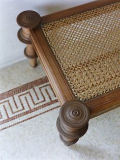 a close up of a wooden bench with wicker on the top and bottom part