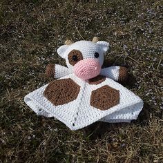 a crochet cow laying on top of a blanket in the grass with text overlay that reads, patch the cow lovey crochet along week 1