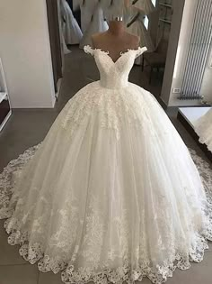 a white wedding dress on display in front of a mirror