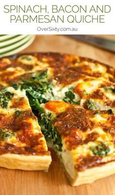 spinach, bacon and parmesan quiche on a cutting board with a slice missing