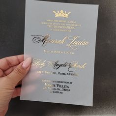 a person holding up a silver and gold wedding card