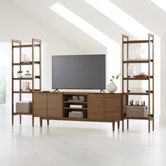 an entertainment center with shelves and a flat screen tv on it's stand in a white room