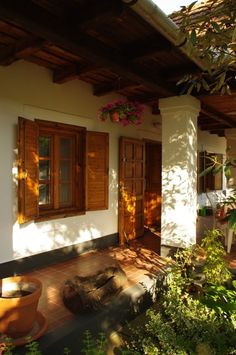 a house with wooden shutters and potted plants